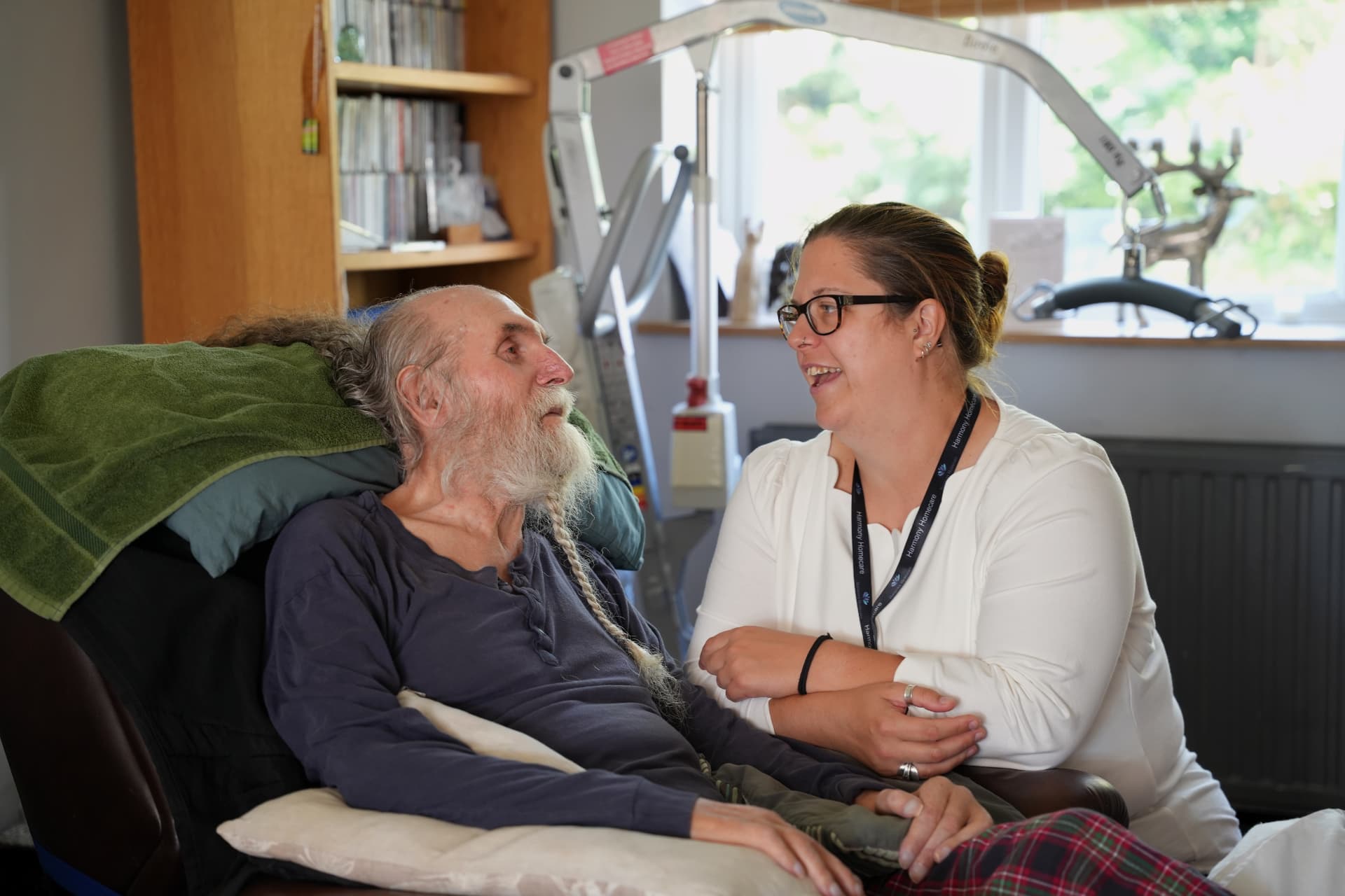 A Harmony Homecare carer sitting and talking with a gentleman in his own front room in Suffolk